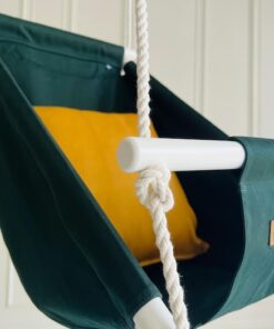 Lähikuva tummanvihreästä vauvakeinusta Ambition keltaisella tyynyllä, käsinmaalattu puukeppi ja Videung-logo